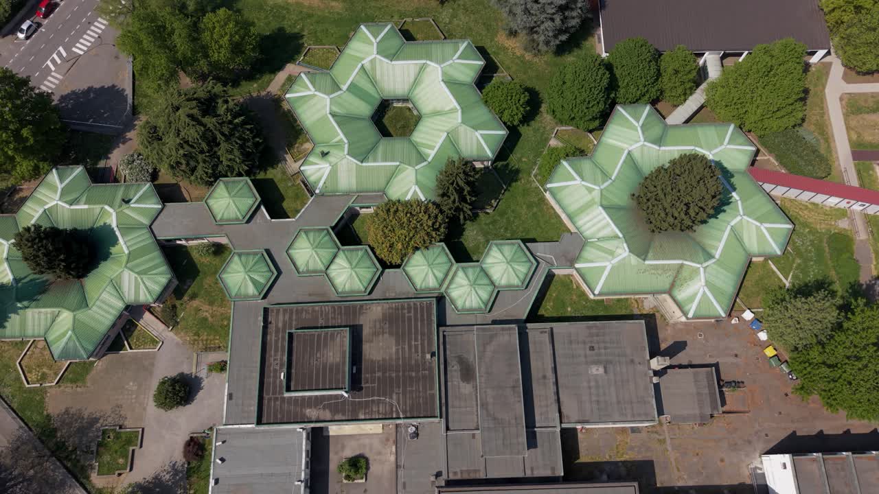 Aerial drone view of a modern public swimming pool sports complex in Peschiera Borromeo near Milan, Italy. Urban infrastructure designed for recreation, fitness, and community sports activities