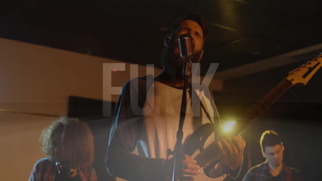 bandmates performing live music on dim stage with electric guitar and animated sound waves