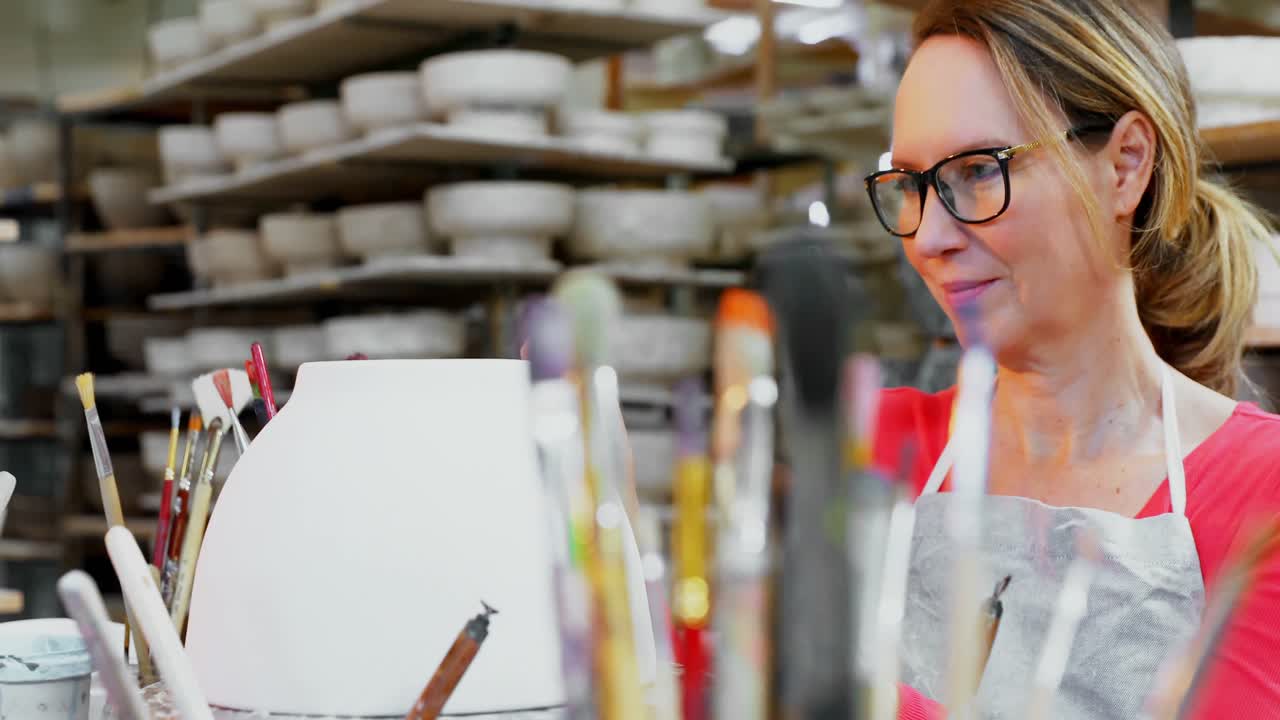 mujer alfarera decorando el cuenco 4k