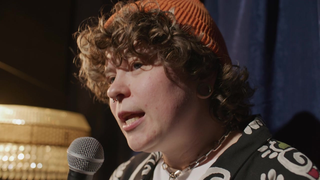 Girl Speaking into Microphone during Stand Up Performance on Stage