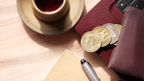 cryptocurrencies on a desk with laptop and coffee cup