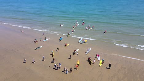 standup paddleboarders entering the waters of duxbury beach for racing event