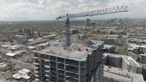 rotating drone shot of crane on top of a hotel construction project