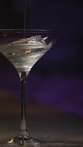 pouring ice into a martini glass