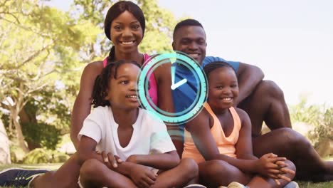 Digitaluhr-Tickt-Vor-Dem-Porträt-Einer-Afroamerikanischen-Familie,-Die-Lächelt,-Während-Sie-Im-Park-Sitzt