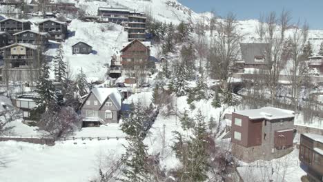 bird's eye view near the cabins and luxury homes in the snowy mountain village of farellones on a sunny day in chile