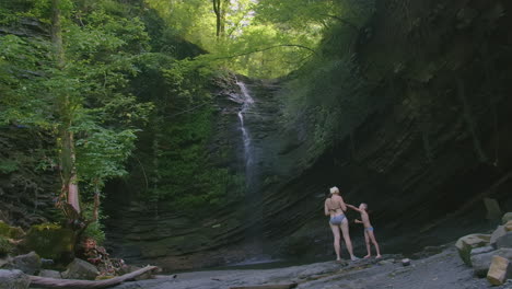 familia disfrutando de una cascada en un bosque exuberante