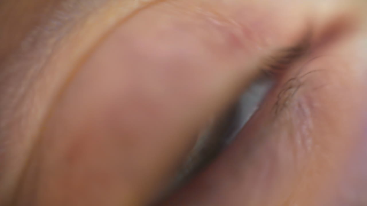 A detailed close-up of a human eye reveals the unique patterns and colors of the iris. Light reflects off the eye, showcasing its natural beauty in bright conditions