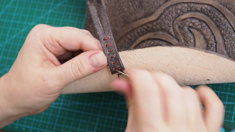 el artesano cosía un bucle para atar el bolso