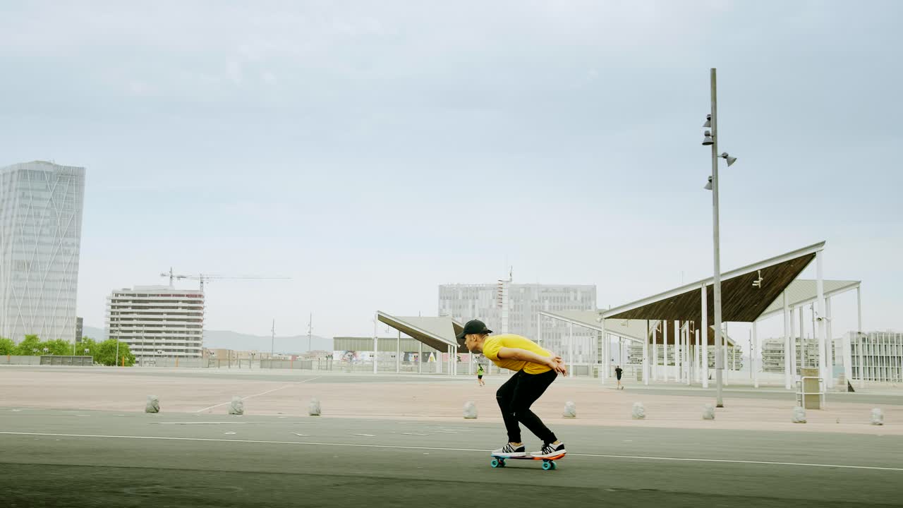 joven y atractivo hombre de moda patinando rápido bajo un panel solar en un día soleado por la mañana con un fondo urbano en cámara lenta