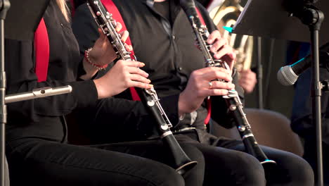 mujeres jóvenes tocando el clarinete en una banda de música