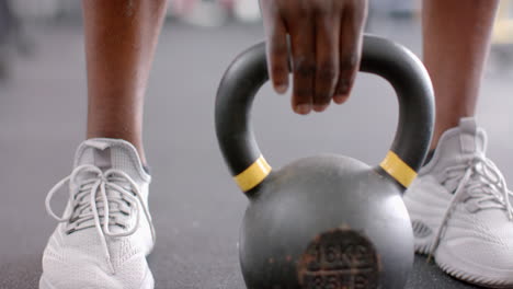 Primer-Plano-De-Calzado-Deportivo-Y-Pesas-Rusas-En-El-Gimnasio.