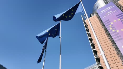 european union flags waving outside the berlaymont building in brussels