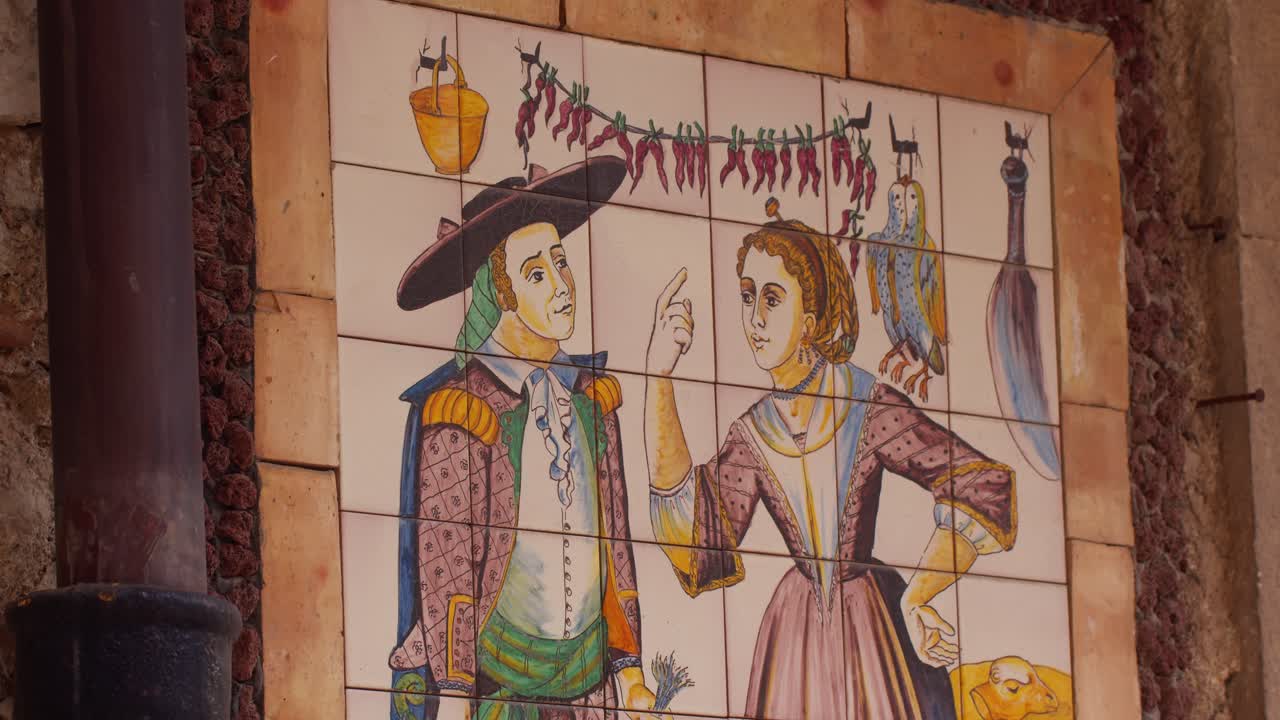 Close-up of a historical tile painting depicting a couple on the walls of Taormina, Sicily, Italy (Sicilia, Italia), showcasing traditional art