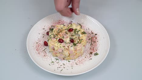 la mano de la mujer hace los granos de granada clásica ensalada rusa olivier