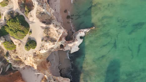 Aerial Birds Eye View showcasing Alvor Portugal cliffs and calm turquoise sea waters