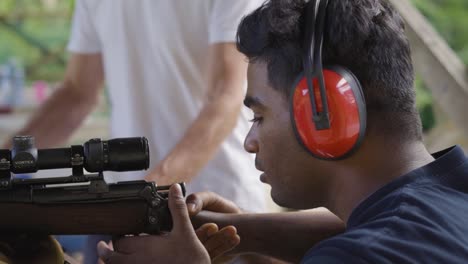 Ayudante-De-Instructor-Hombre-Sujetando-Rifle-Apuntando-Al-Objetivo-En-El-Polígono-De-Tiro