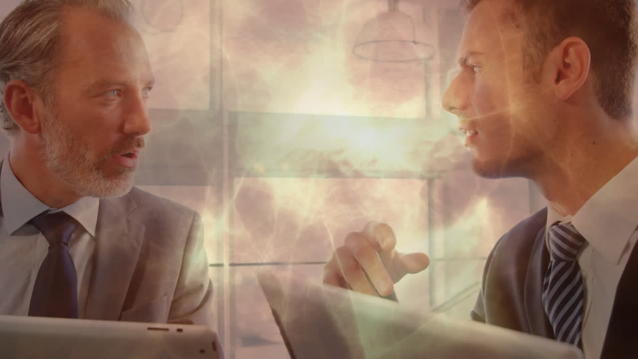 태블릿을 사용하는 두 명의 백인 사업가에 대한 빛의 애니메이션