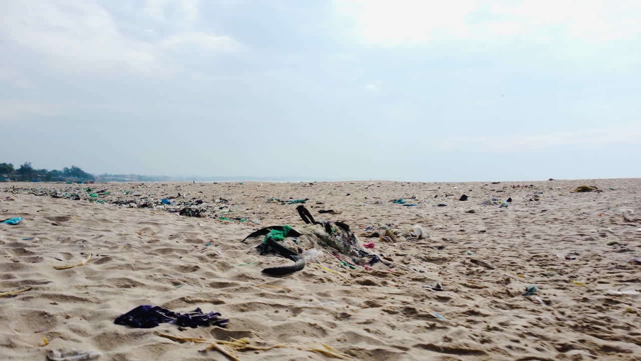 vuelo aéreo bajo sobre la arena de la playa con basura, vietnam