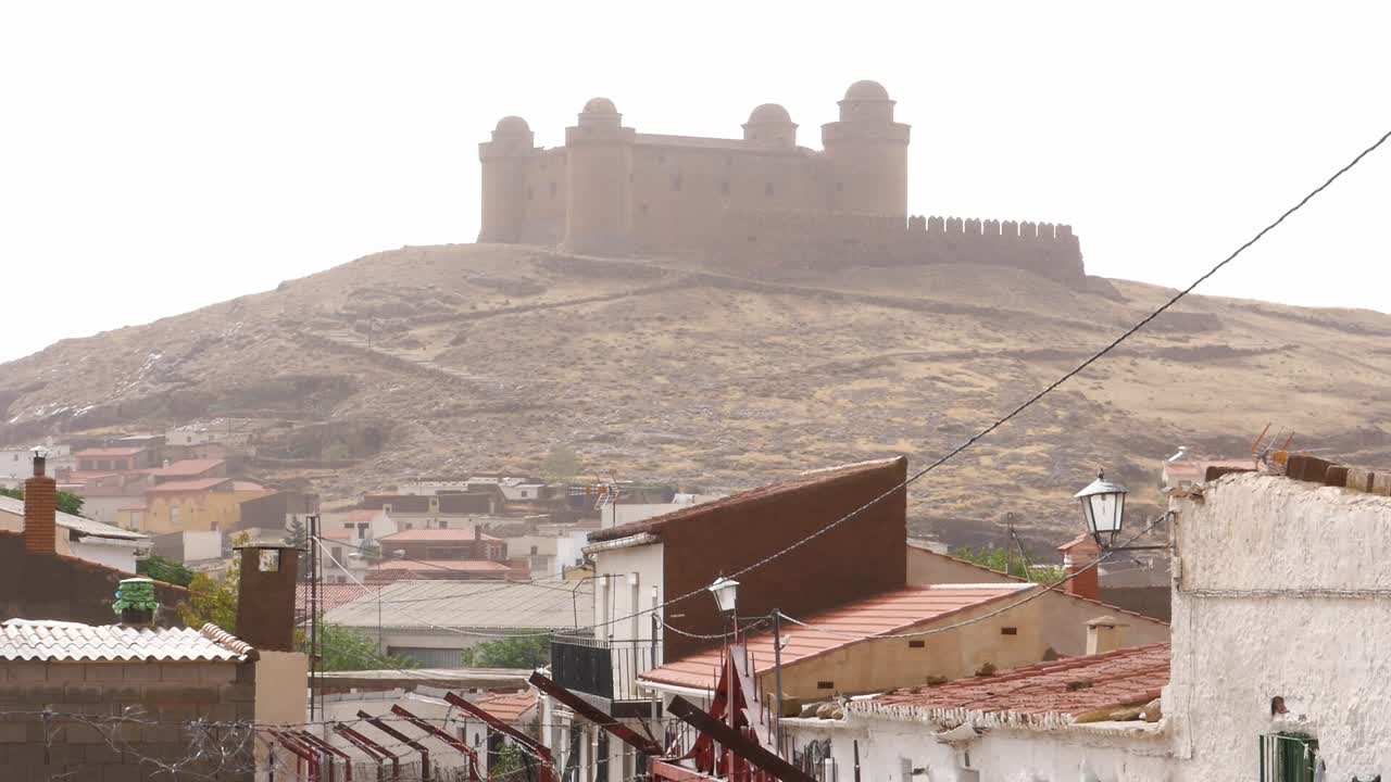 La Calahorra Castle overlooks the town of the same name in Granada, Spain. The fortress dominates the hill on a misty day