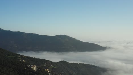 sea of clouds over valley with green mountains at sardinia, italy. - aerial