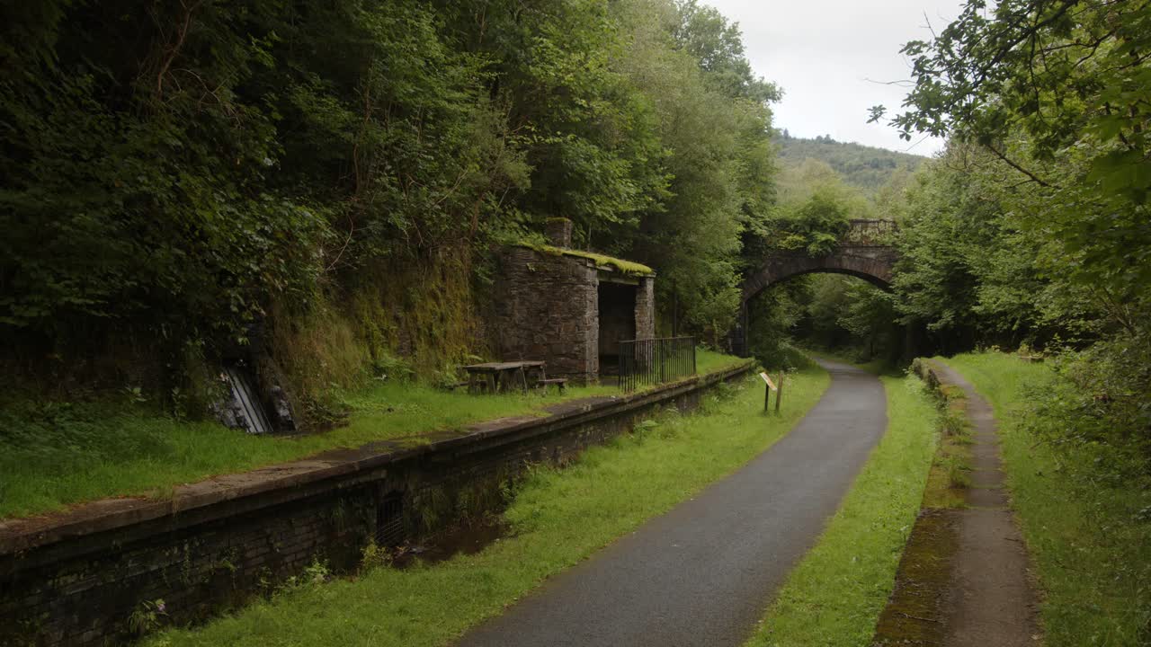 tomada ancha de la estación de cynonville con el viejo puente ferroviario en el fondo y el sendero para bicicletas