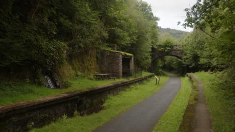 Weitwinkelaufnahme-Des-Bahnhofs-Cynonville-Mit-Alter-Eisenbahnbrücke-Im-Hintergrund-Und-Radweg