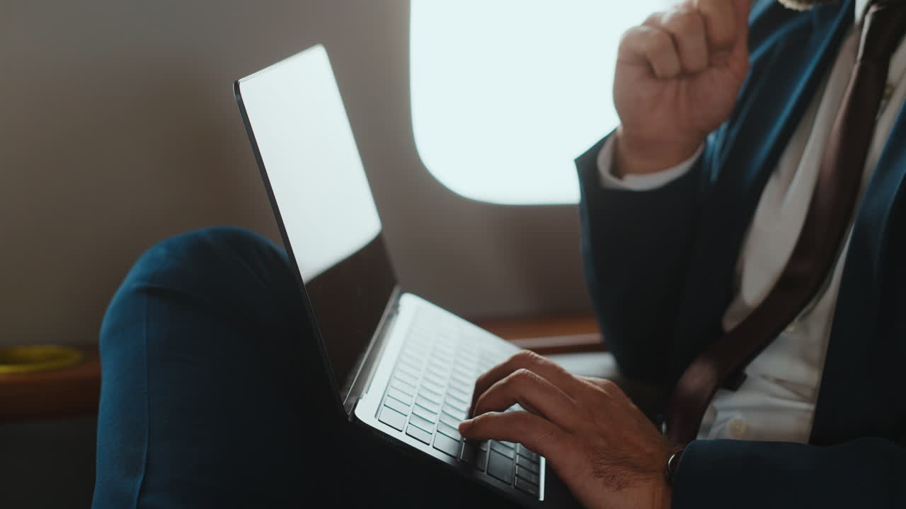 бизнесмен, работающий на ноутбуке в частном самолете