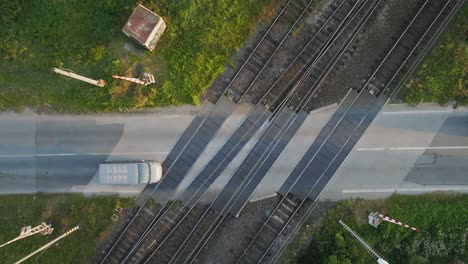 aerial top down view of passenger cars crossing railway crossing on asphalt road