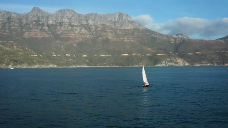 sailboat in the ocean with mountains in the background