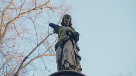 Gimbal-shot-of-a-gravestone-angel-statue-at-an-old-gothic-cemetery-on-a-sunny-winters-day