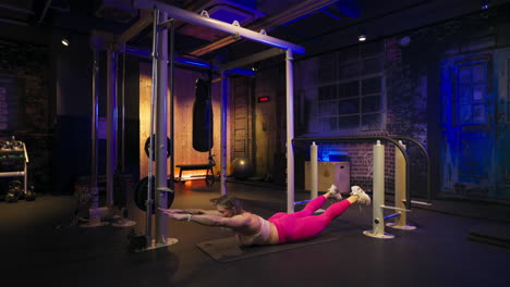 Adult girl doing a gluteal and lumbar exercises on a mat at the gym