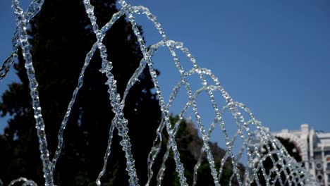 fountain with water jets falling on center in city park at summer day.