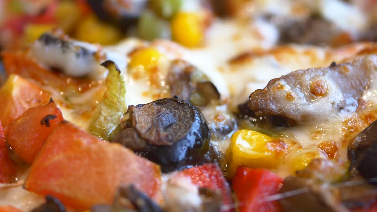 primer plano de una pizza vegetariana con queso, setas, pimientos, maíz y aceitunas