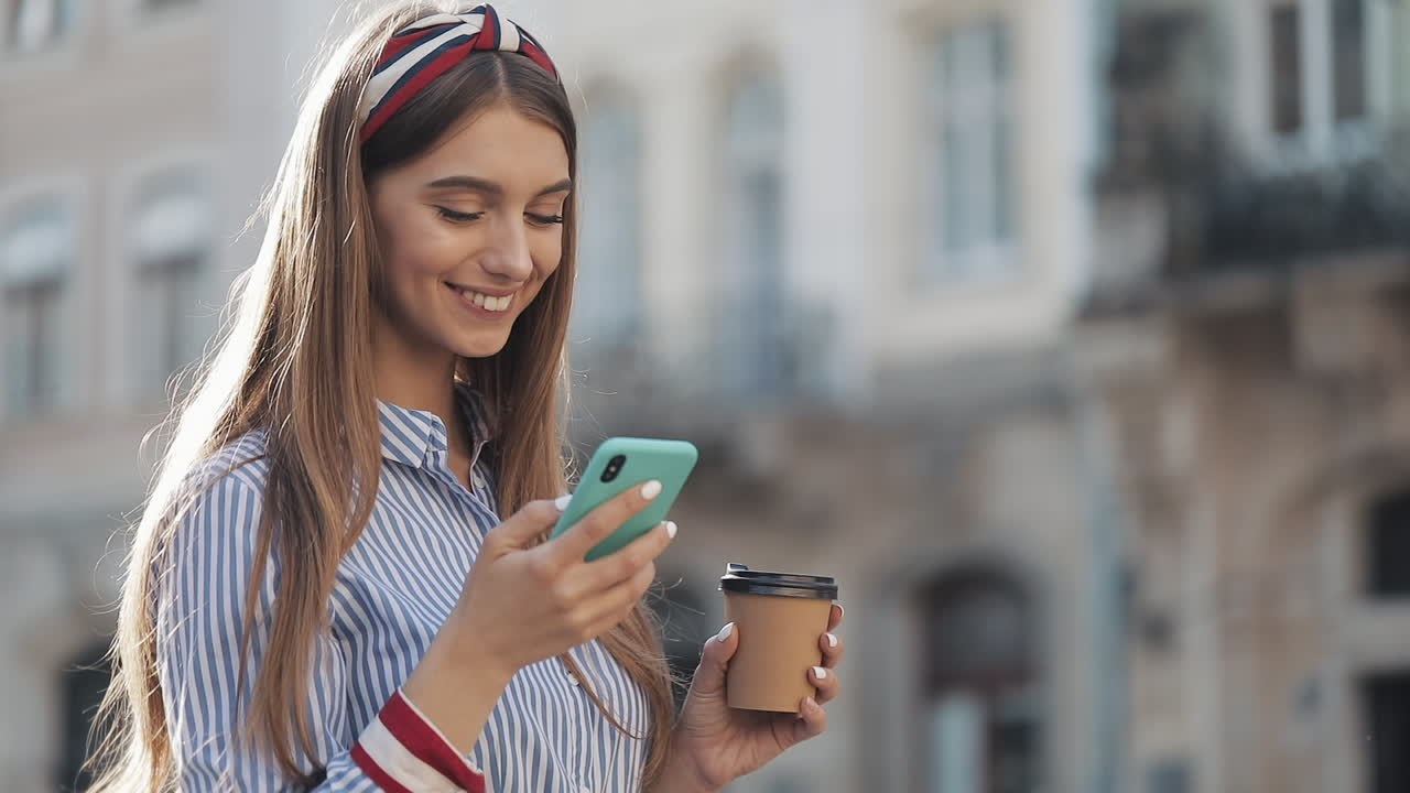 Jovem enviando mensagem de voz pelo smartphone na cidade.