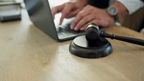 ley, mesa y manos escribiendo en una computadora portátil