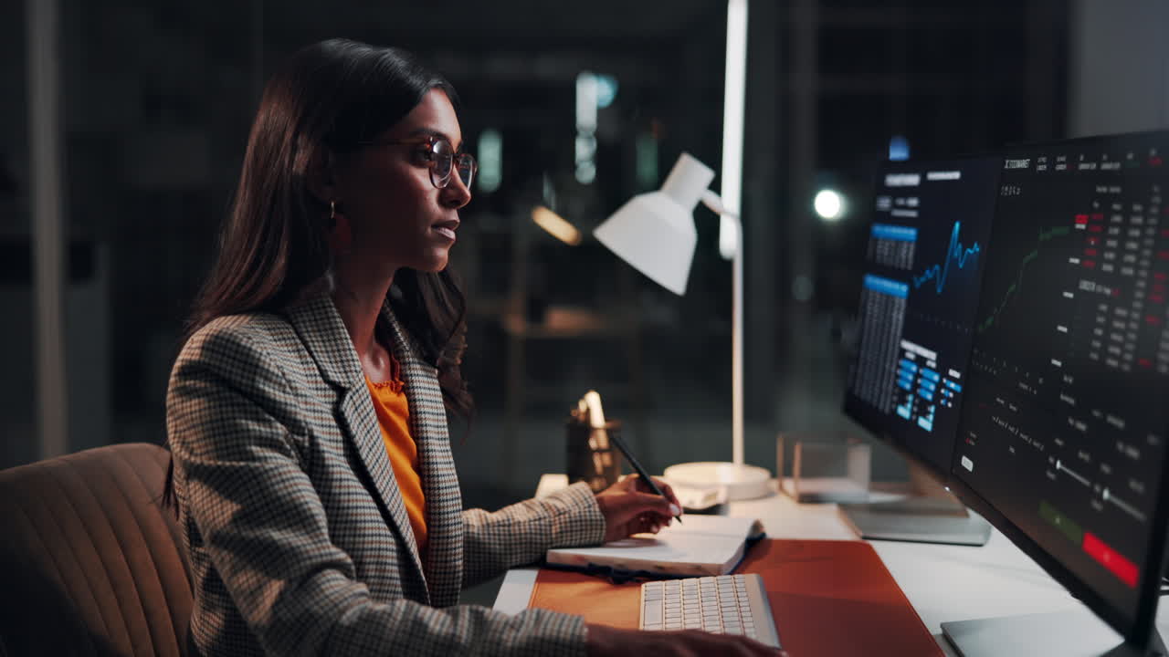 Donna professionista che analizza dati finanziari al computer in ufficio di notte