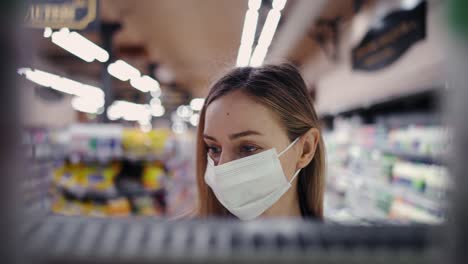 Footage-from-the-shelf---woman-in-mask-picking-milk-bottle-from-the-shelf