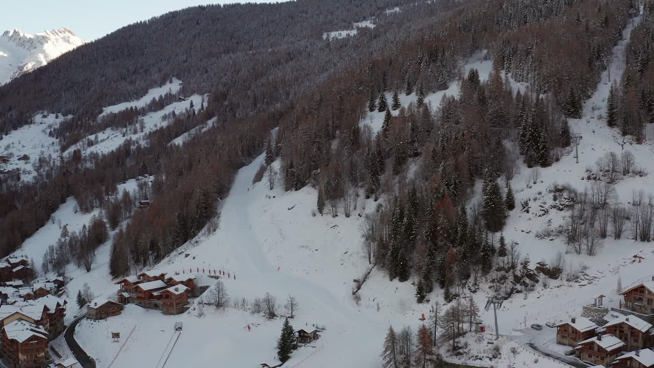 Aerial view of the ski slopes before season opening during sunset. Orbit shot