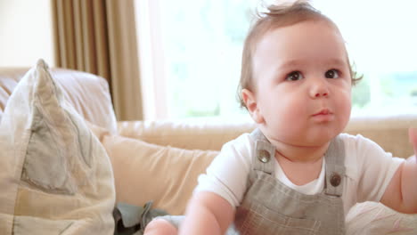 happy baby boy playing on sofa at home