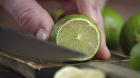 hands men cut off a piece of juicy lime on a cutting board.