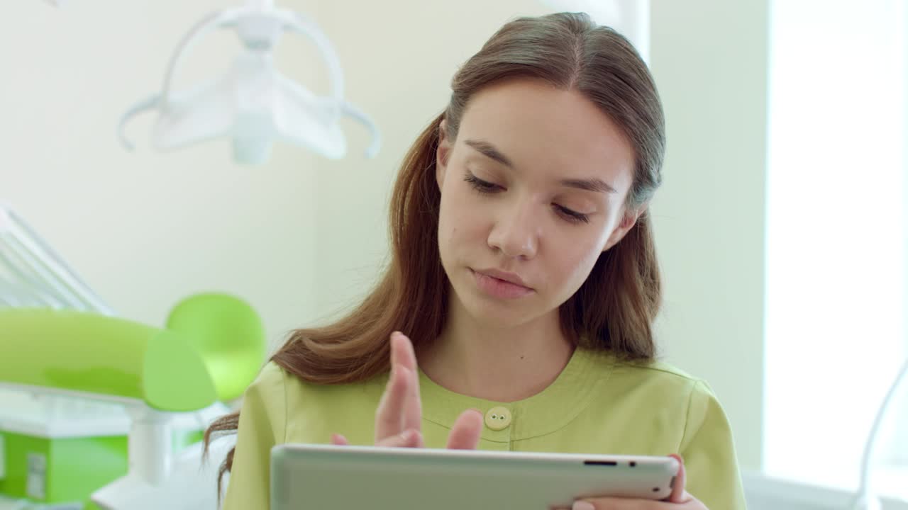 mujer dentista usando una tableta en el consultorio dental. médico trabajando en una tableta