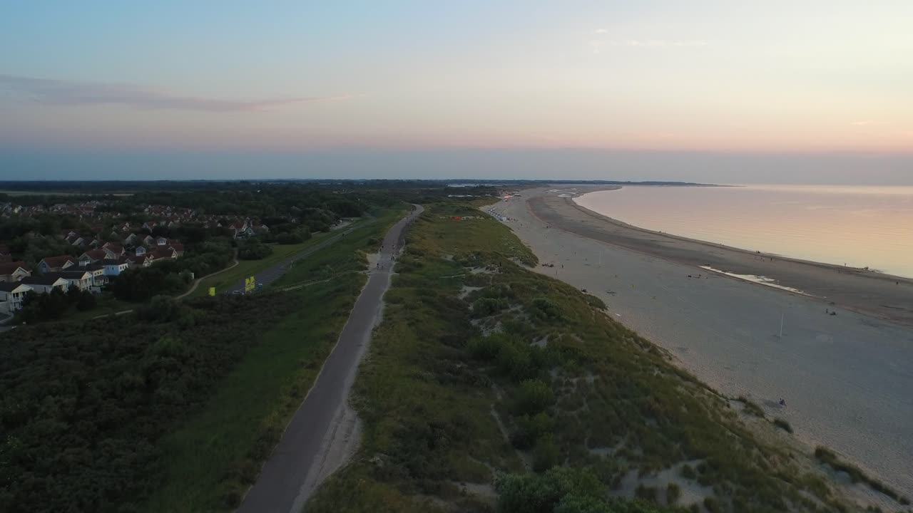antena: la playa alrededor de la barrera de mareas de tormenta de oosterschelde durante una puesta de sol de verano