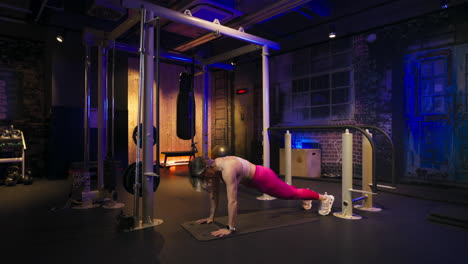 fitness athlete crunches knee to elbow, advanced exercise in a neon lit gym, improving muscle flexibility and mobility