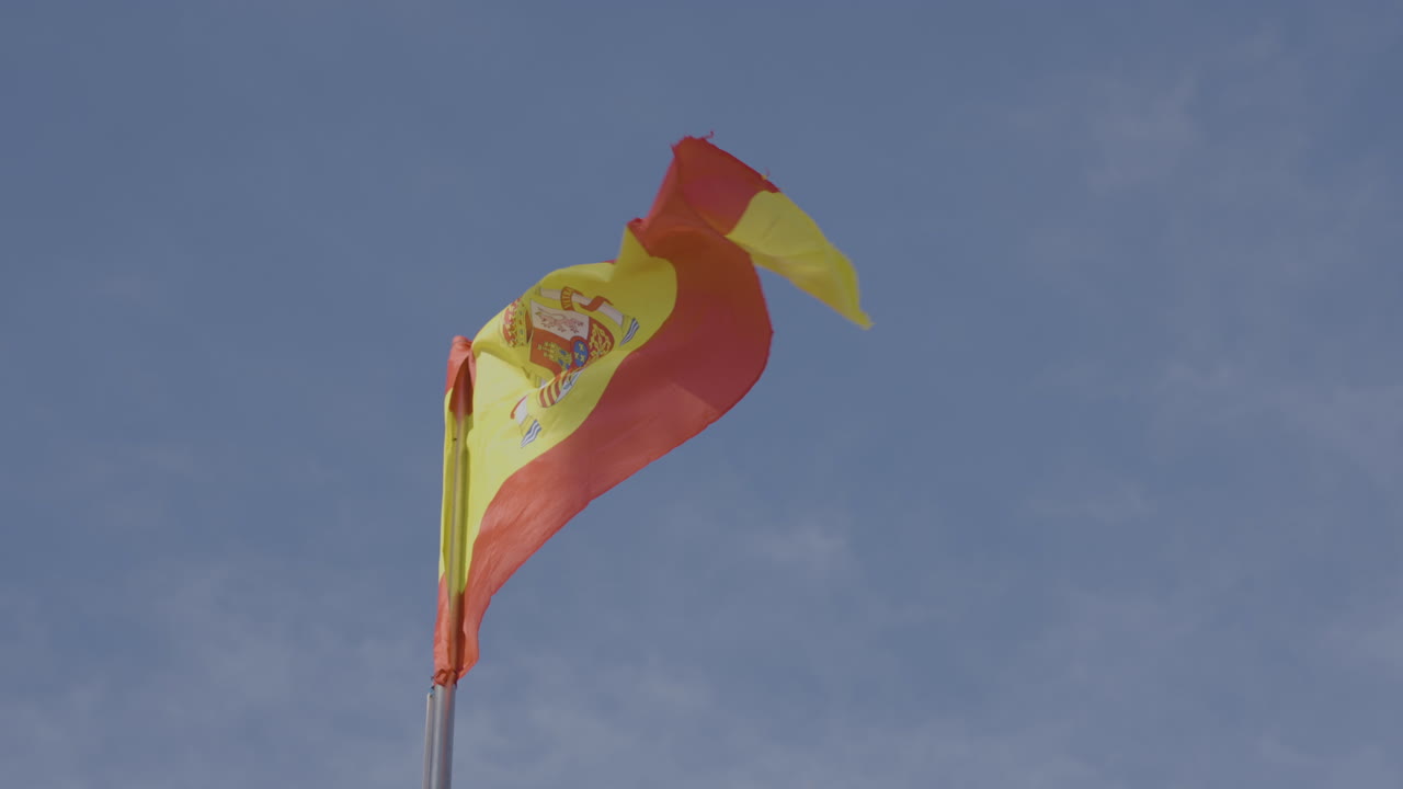 bandera nacional española ondeando a cámara lenta en un día soleado