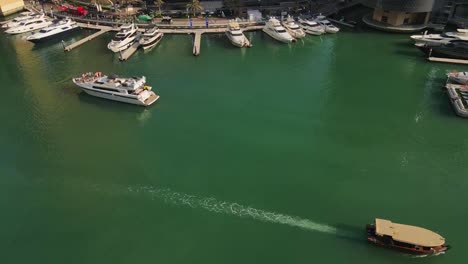 aerial drone footage of dubai marina showcasing its iconic waterfront, and a serene collection of boats and yachts