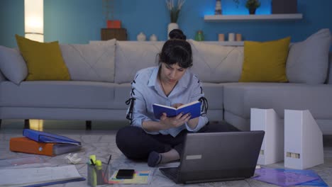 una trabajadora de oficina en casa leyendo un libro.
