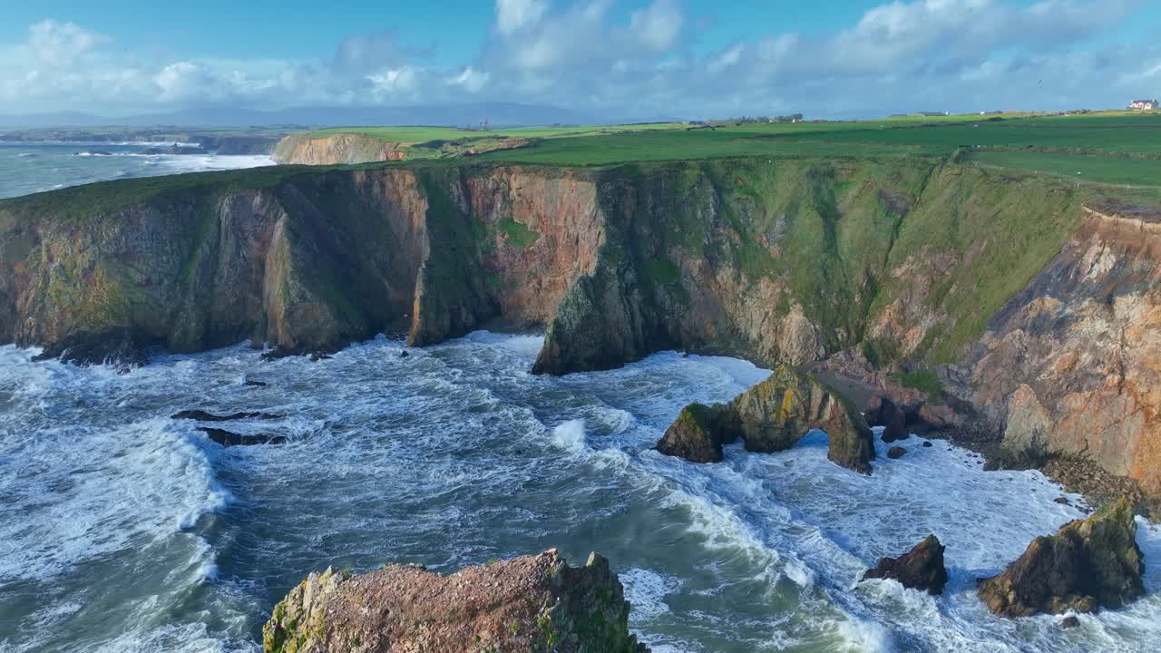 Ireland epic locations seascape dramatic waves batter Waterford Coast in autumn storm sea cliffs scarred by coastal erosion