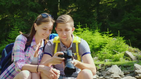 Ein-Glückliches-Touristenpaar-Schaut-Sich-Die-Aufgenommenen-Fotos-Auf-Der-Kamera-An,-Toller-Urlaub-Und-Gut-Ich