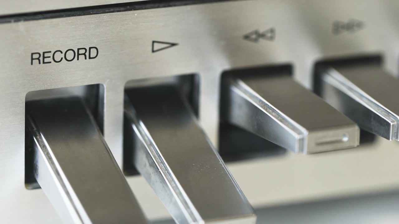 woman tunes tape recorder, buttons close-up